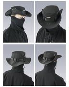 Black hat with face covering worn by a person on a gray background