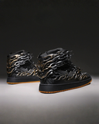Black high-top sneakers with metallic flame design on a dark background