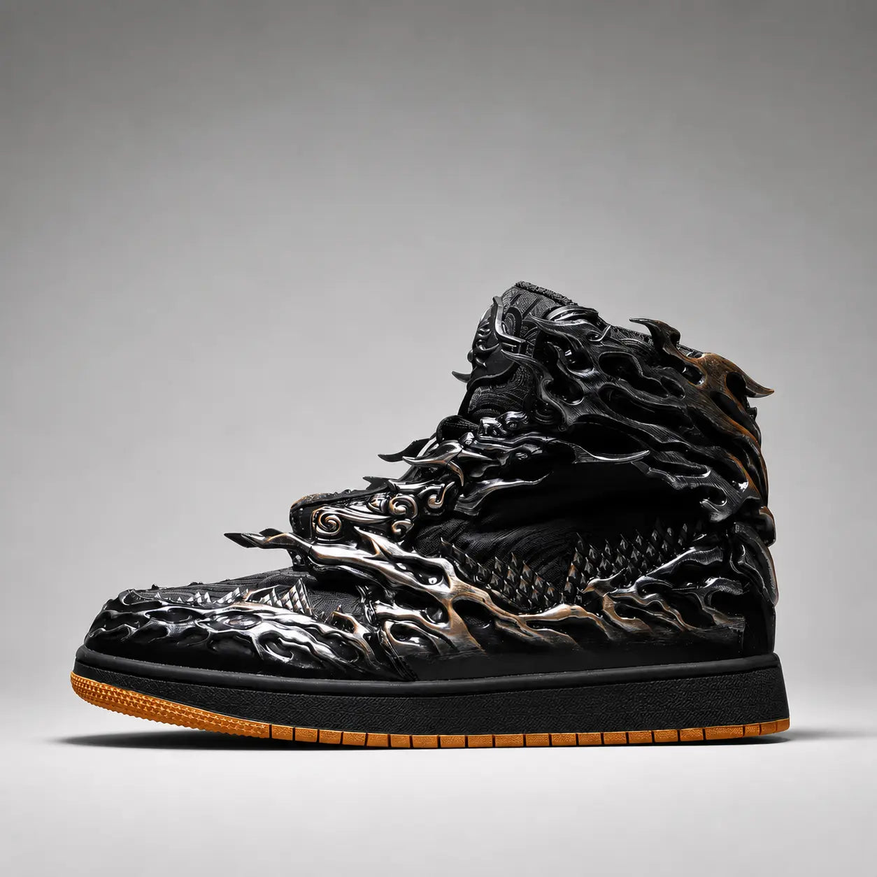 A single high-top sneaker shown in profile against a neutral gray studio background. The shoe is predominantly black with metallic bronze and gold dragon-like sculpted overlays and a gum brown outsole.