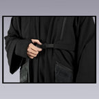 A man fastens the chest belt of the techwear ninja black kimono