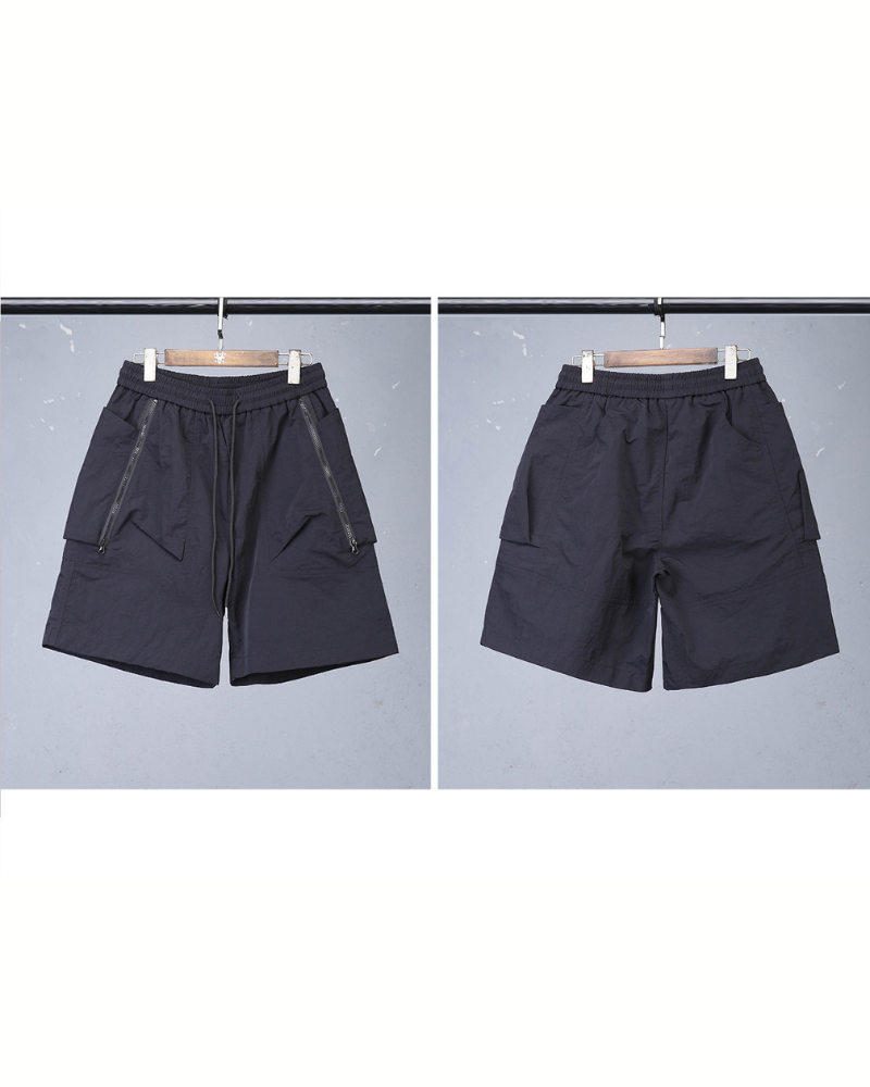 Black shorts on hangers against a gray background
