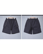 Black shorts on hangers against a gray background