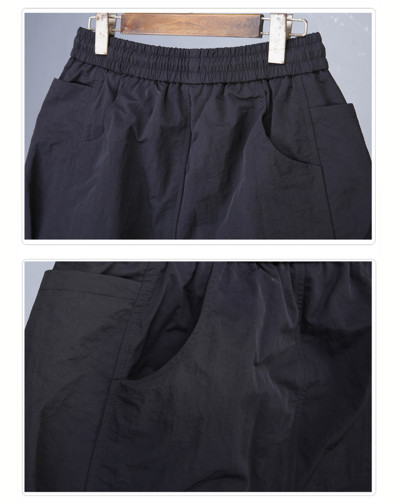 Black pants displayed on a hanger against a gray background