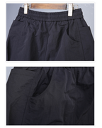 Black pants displayed on a hanger against a gray background