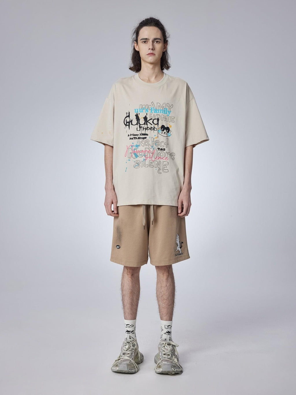 Teenager wearing trendy khaki shorts with a playful cat print. Cropped length and mid-rise waist for summer comfort.