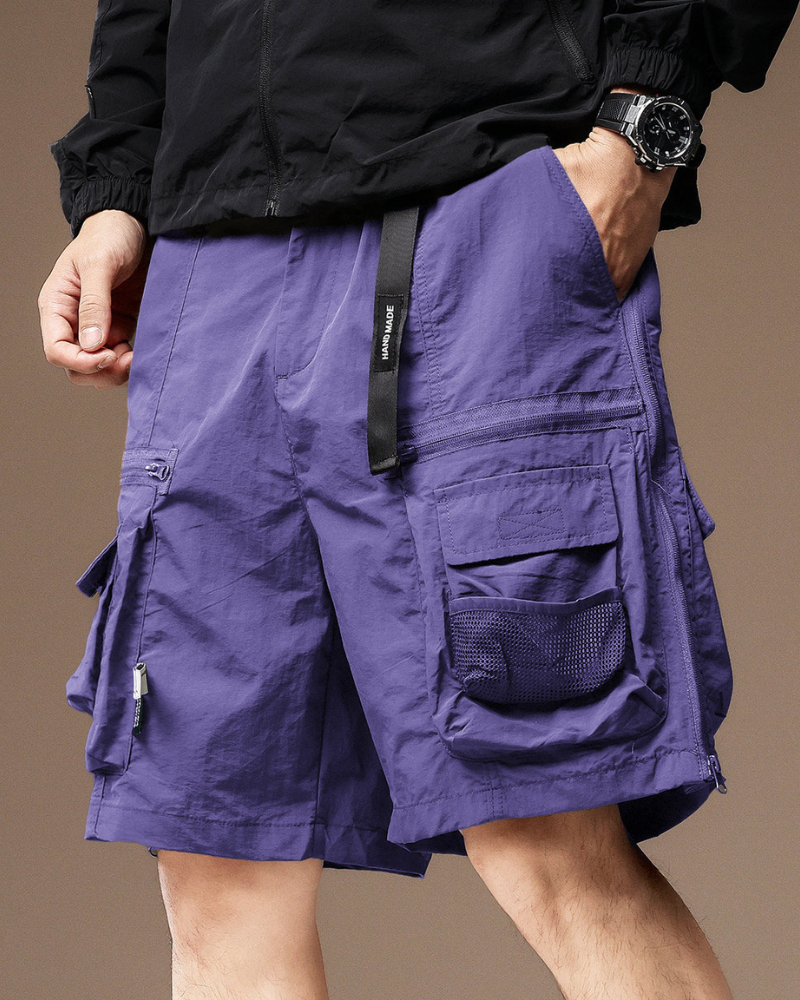 Person wearing purple cargo shorts with a black jacket on a brown background