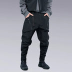 A man is wearing Techwear pants and putting his hands inside his pockets.
