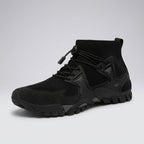 A black high-top athletic sneaker with a knit sock-like collar, lace-up front, and rugged sole, shown on a light gray studio background.