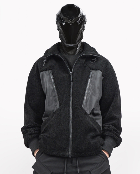 Person wearing a black and gray jacket with a unique helmet on a white background