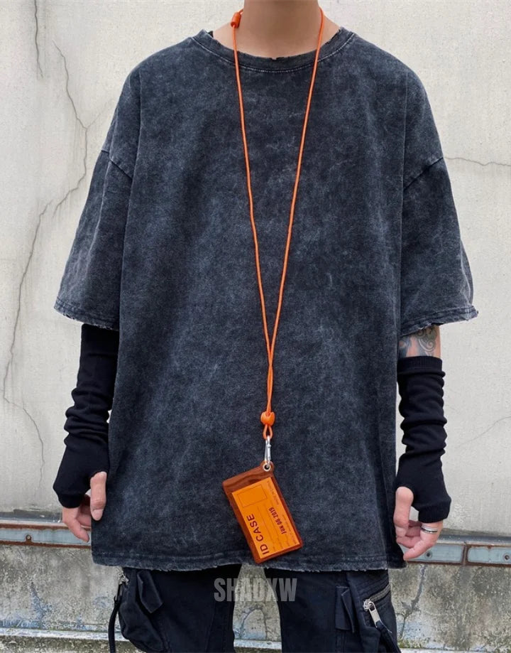 Oversized washed black techwear t-shirt with a long hem, muted charcoal finish, and minimalist urban streetwear styling — view 5