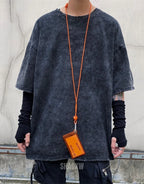 Oversized washed black techwear t-shirt with a long hem, muted charcoal finish, and minimalist urban streetwear styling — view 5
