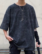 Oversized washed black techwear t-shirt with a long hem, muted charcoal finish, and minimalist urban streetwear styling — view 4