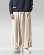 Clotechnow wide-leg hakama pants in beige corduroy with a draped silhouette and elastic waist, paired with sneakers.
