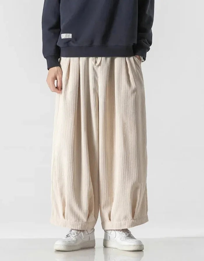 Clotechnow beige corduroy hakama pants with a wide-leg draped silhouette and elastic waist, styled with white sneakers