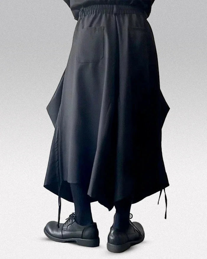 Clotechnow black baggy hakama pants with a wide-leg draped silhouette and elastic waistband worn with black shoes