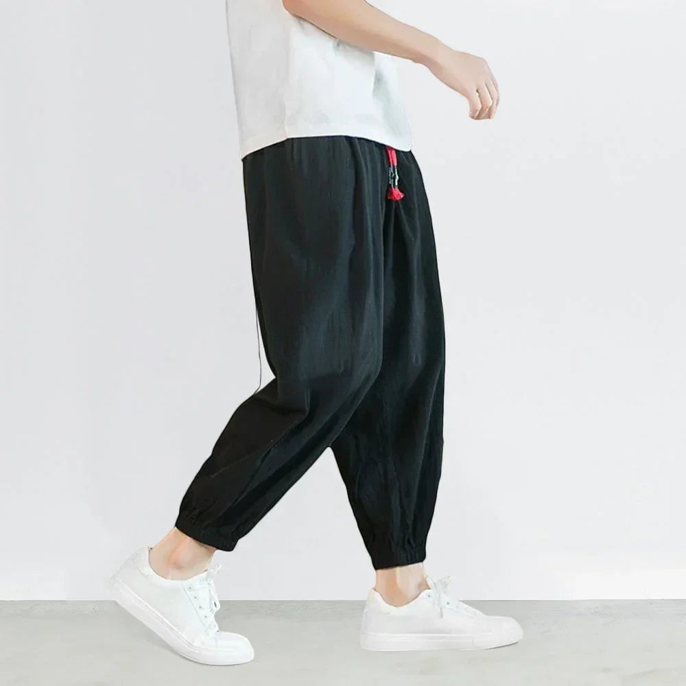 Clotechnow black chino fold hakama pants with a wide-leg draped silhouette and elastic cuffs worn with white sneakers