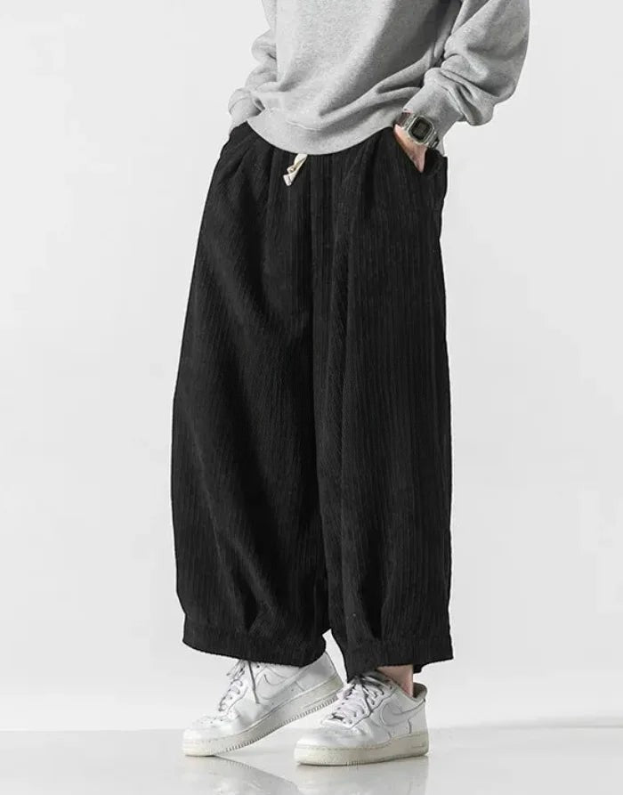 Clotechnow black corduroy hakama pants with a wide-leg silhouette and drawstring waist worn with white sneakers