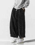 Clotechnow black corduroy hakama pants with a wide-leg silhouette and drawstring waist worn with white sneakers