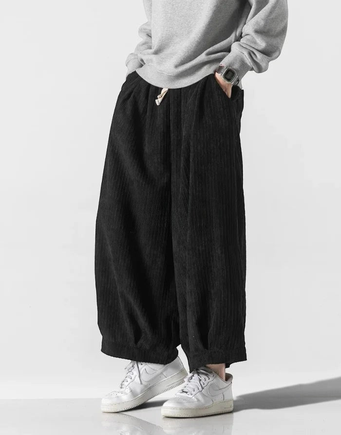Clotechnow black corduroy hakama pants with a wide-leg silhouette and drawstring waist worn with white sneakers