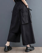 Clotechnow black double-layer hakama pants with a wide-leg silhouette and side tie details worn with chunky shoes.