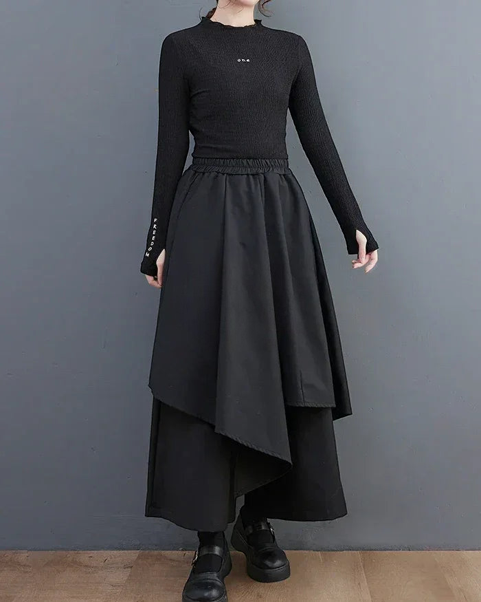 Clotechnow black formal drape hakama pants with a layered asymmetrical hem worn with a black long-sleeve top