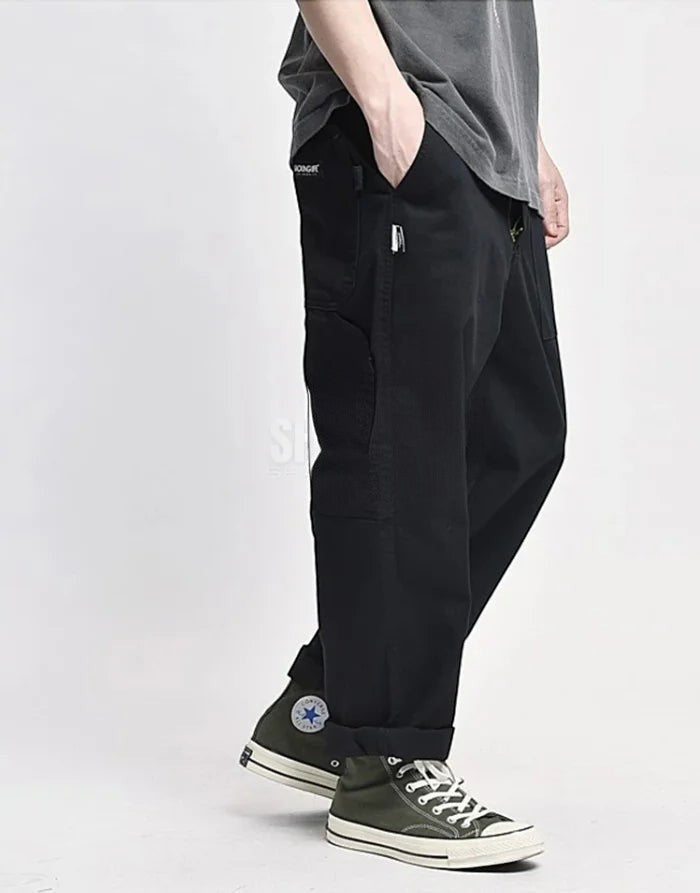 Clotechnow black multi-utility hakama pants with a wide-leg silhouette and side pockets worn with high-top sneakers