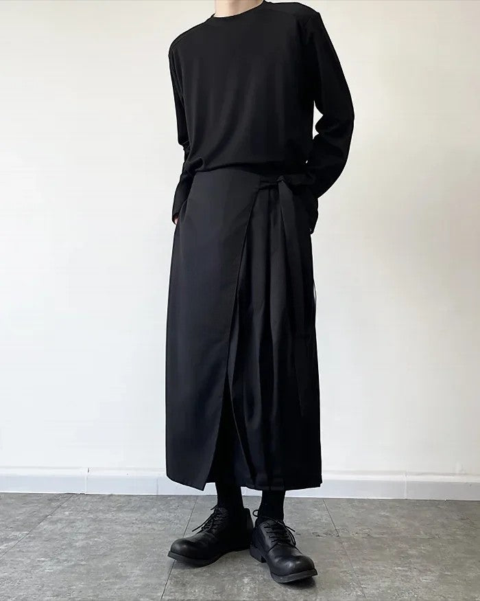 Clotechnow black kimono cut hakama pants with a wide-leg draped silhouette worn with a long-sleeve top and boots.