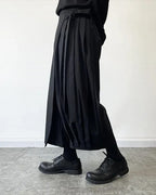 Clotechnow black wide-leg hakama pants with pleated detailing and a draped silhouette worn with black leather shoes