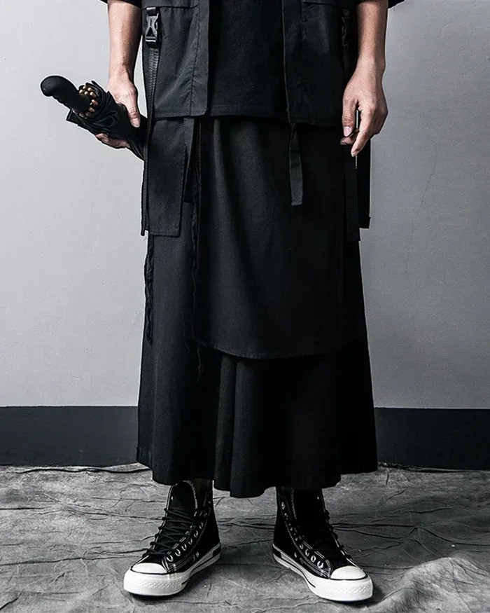 Clotechnow black wide-leg hakama pants featuring deep pleats and a layered techwear aesthetic with high-top sneakers.