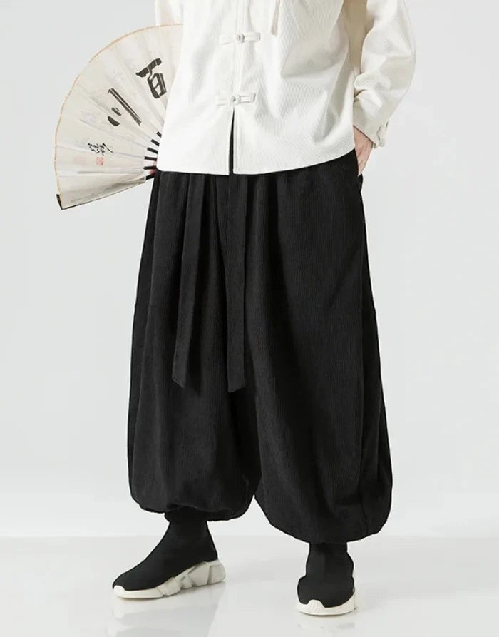 Clotechnow black wide-leg Ribbon Tie Hakama Pants with a draped silhouette, worn with a white top and folding fan.