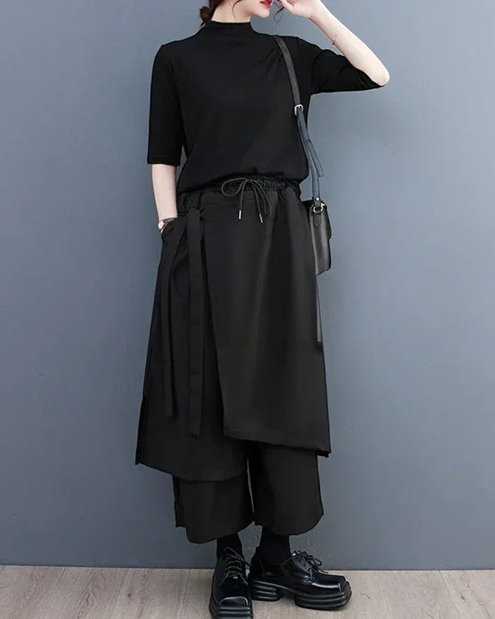 Clotechnow black sculpted hakama pants with a wide-leg draped silhouette, drawstring waist, and layered fabric panels.