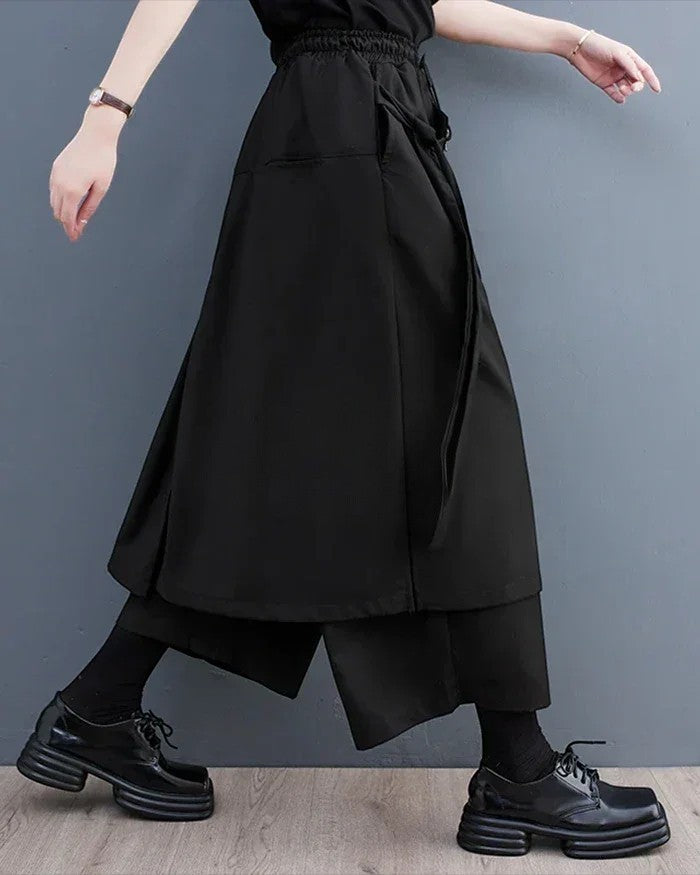 Clotechnow black sculpted hakama pants with a wide-leg draped silhouette and elastic waist worn with platform shoes