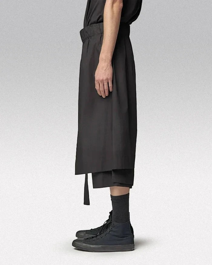 Clotechnow black short-length hakama pants with a wide-leg draped silhouette, side view on a model.