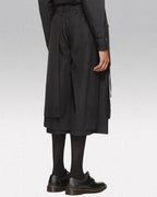 Clotechnow contemporary black short hakama pants with a wide-leg draped silhouette worn with dark socks and shoes