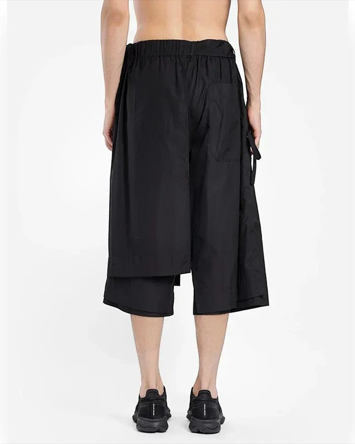 Clotechnow black short-length hakama pants with a wide-leg draped silhouette and elastic waistband, rear view.
