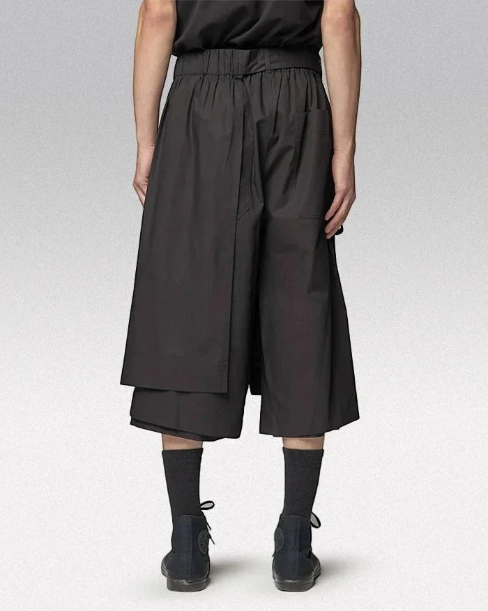 Clotechnow black short-length hakama pants with a wide-leg draped silhouette and elastic waistband, rear view