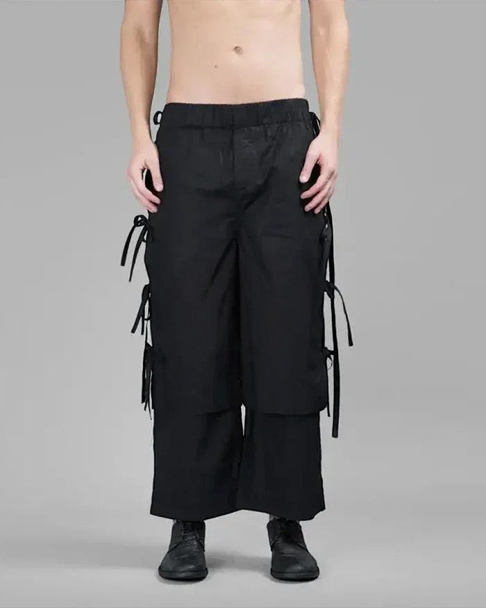 Clotechnow black wide-leg hakama pants with side tie details and tapered cuffs worn by a model