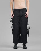 Clotechnow black wide-leg hakama pants with side tie details and a tapered cuff, worn by a shirtless model.