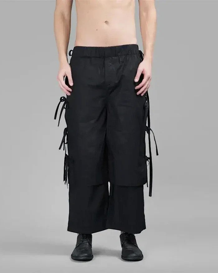 Clotechnow black wide-leg hakama pants with side tie details and a tapered cuff, worn by a shirtless model.