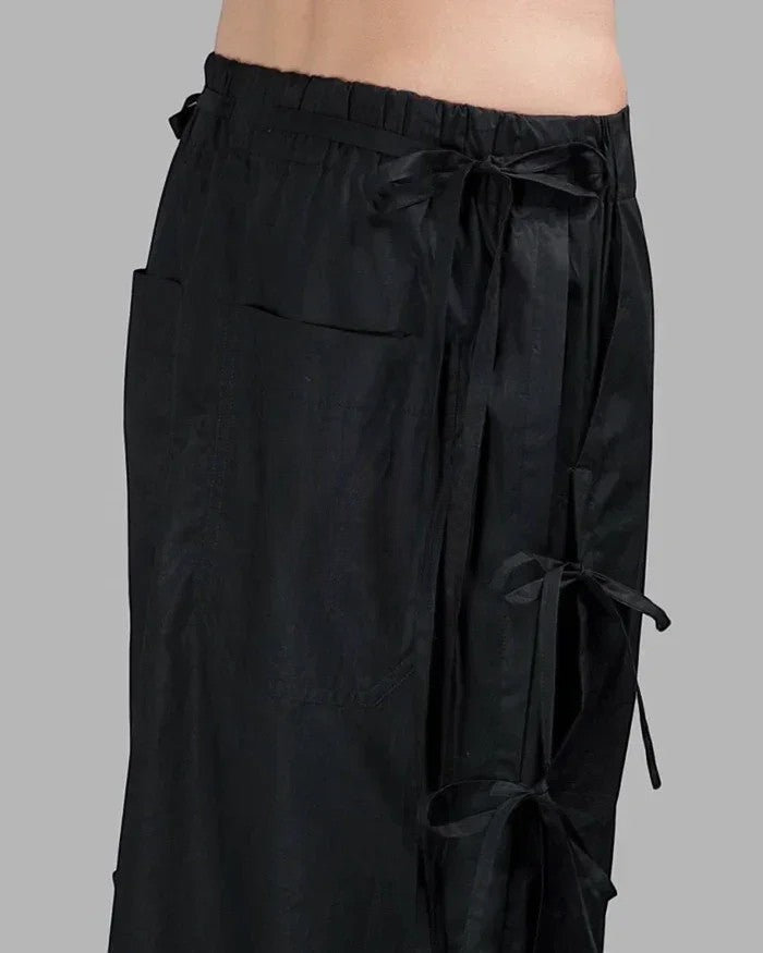 Clotechnow black taper cuff hakama pants featuring a wide-leg draped silhouette and adjustable side tie details.