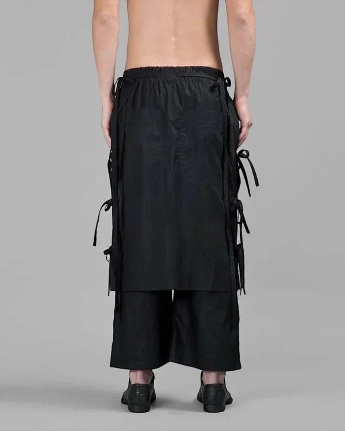 Back view of Clotechnow black taper cuff hakama pants with wide-leg draped silhouette and side tie details