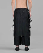 Back view of Clotechnow black taper cuff hakama pants with wide-leg draped silhouette and side tie details