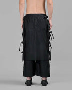 Clotechnow black wide-leg hakama pants with side tie details and layered fabric panels viewed from the back.