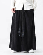 Clotechnow black wide-leg hakama pants with vertical texture and embroidered detailing on the front ties