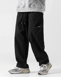 Clotechnow black wide-leg hakama pants with a drawstring waist and side pockets worn with grey sneakers