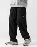 Clotechnow black wide-leg hakama pants with a drawstring waist and side pockets worn with grey sneakers