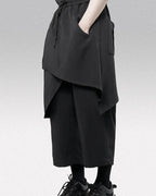 Clotechnow black wide-leg hakama pants with a draped layered design and drawstring waist for a modern streetwear look.