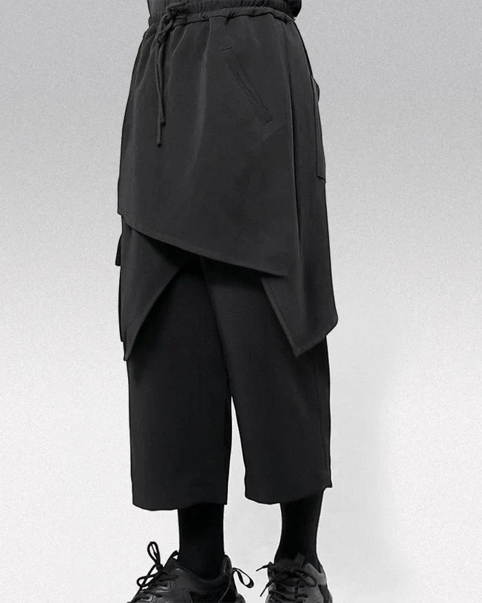 Clotechnow black wide-leg hakama pants with a draped layered design and drawstring waist for a modern streetwear look.