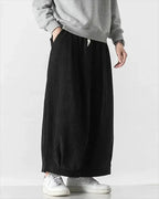 Clotechnow black wide-leg hakama pants with a textured fabric and relaxed fit worn with a grey sweatshirt.