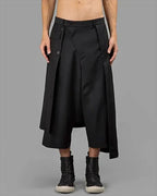 Clotechnow black wide-leg hakama pants with a layered wrap design and button closure worn with dark boots